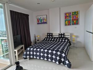 a bedroom with a black and white comforter on a bed at Diamond Suites Resort in Pattaya South