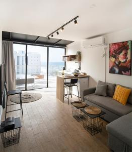 a living room with a couch and a kitchen at Sublet TLV 270 in Tel Aviv