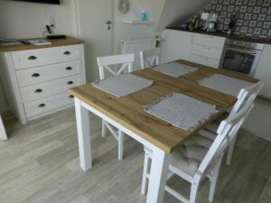 a kitchen with a wooden table and white cabinets at Ferienwohnung Backbord in Büsumer Deichhausen