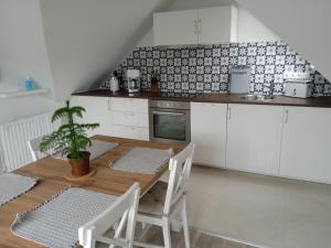 a kitchen with a wooden table and white cabinets at Ferienwohnung Backbord in Büsumer Deichhausen