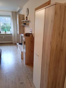 a kitchen with a large wooden cabinet and a table at Kleine Auszeit am Meer in Büsum
