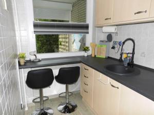 a small kitchen with two chairs and a sink at Kleine Auszeit am Meer in Büsum +7 photos