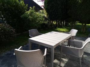 una mesa y sillas con una mesa y sillas blancas en Ferienwohnung Steuerbord, en Büsumer Deichhausen