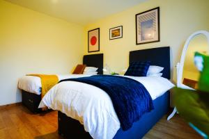 a bedroom with two beds and a mirror at Eagle homely apartment in Kettering
