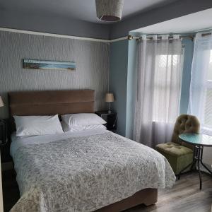 a bedroom with a bed and a chair and a window at Eask View Dingle - Room Only in Dingle