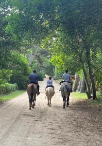 drie mensen die paardrijden op een onverharde weg bij BOSQUE LIBERTAD Casa PB in Mar Azul