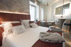 a bedroom with a large white bed with towels on it at Tritone Luxury Suites Fontana di Trevi in Rome