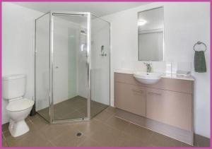 a bathroom with a shower and a toilet and a sink at Apartment 1102 | 11th Floor River & Stadium Views in Townsville
