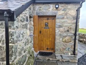 a stone building with a wooden door on it at The Bothy in Caernarfon