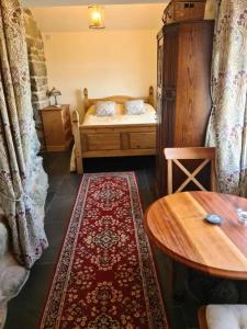 a room with a bed and a table and a rug at The Bothy in Caernarfon