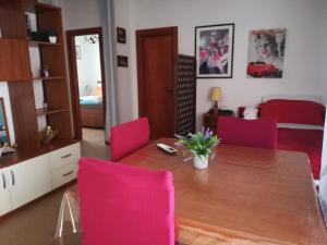 a living room with a wooden table and pink chairs at TERRAZZA LA LOGGIA - Appartamento Panoramico in San Foca