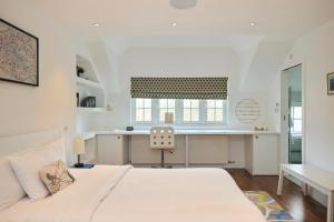 a white bedroom with a bed and a desk at The Clapham Crib - Spacious 4BDR House with Patio in London