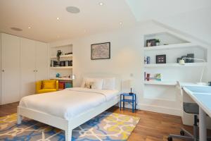 um quarto branco com uma cama e um lavatório em The Clapham Crib - Spacious 4BDR House with Patio em Londres