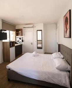 a large white bed in a room with a kitchen at Sublet TLV 270 in Tel Aviv