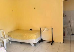 um quarto com uma cama e uma parede amarela em Casa na em moitas de Amontada em Praia de Moitas