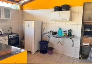 uma cozinha com um frigorífico branco e um lavatório em Casa na em moitas de Amontada em Praia de Moitas