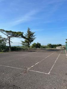 un parking vide avec un court de tennis dans l'établissement Shire Cottage - Crackington Haven, Cornwall, à Saint Gennys
