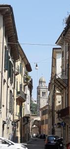 una strada con edifici e una torre dell'orologio in lontananza di Circolo Vitale, Little Verona a Verona