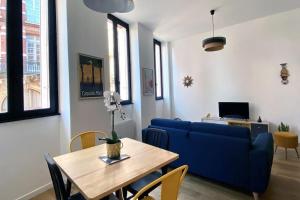 圖盧茲的住宿－Le T2 Capitole - Hypercentre - Metro - Wifi，客厅配有蓝色的沙发和桌子