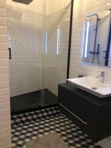 圖盧茲的住宿－Le T2 Capitole - Hypercentre - Metro - Wifi，一间带水槽和玻璃淋浴的浴室