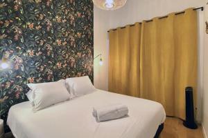 圖盧茲的住宿－Le T2 Capitole - Hypercentre - Metro - Wifi，一间卧室设有一张大床和大型花卉墙
