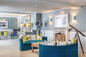 a living room with two blue chairs and a fireplace at Harbour Hotel & Spa Sidmouth in Sidmouth