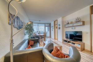 ein Wohnzimmer mit einem Sofa und einem TV in der Unterkunft Ferienpark - Haus N, App 0N0301 in Heiligenhafen