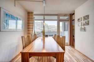 a dining room table with chairs and a large window at Ferienpark - Haus N, App 0N0301 in Heiligenhafen