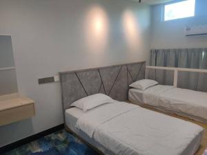 - une chambre avec 2 lits et une fenêtre dans l'établissement Homestay Sandakan SpringField, à Sandakan