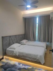 - une chambre avec 2 lits et un ventilateur de plafond dans l'établissement Homestay Sandakan SpringField, à Sandakan
