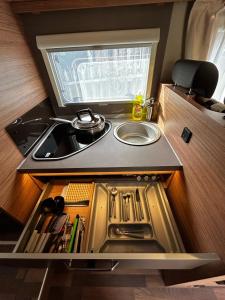 eine kleine Küche mit einem Waschbecken und einem Waschbecken in der Unterkunft London Explorers' Pod, Vaaroom in Romford