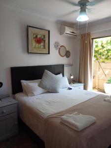 a bedroom with a large bed with two towels on it at Cura Lodge in Bloemfontein