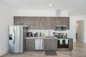 a kitchen with stainless steel appliances and wooden cabinets at Contemporary 2BR I Gym I Parking I Workspace in Dallas