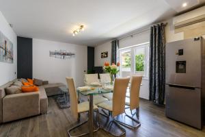 a kitchen and living room with a table and chairs at Villa Mihaela with private pool, jacuzzi and free secure parking in Trogir