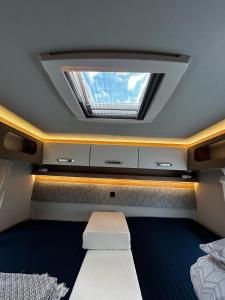 Schlafzimmer mit einem Dachfenster und einem Bett in der Unterkunft London Explorers' Pod, Vaaroom in Romford