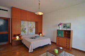 een slaapkamer met een bed en een tv. bij Villa Olivella in Sale Marasino