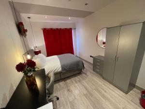 a bedroom with a bed and a red curtain at Letzi private en-suite Near Wembley in London
