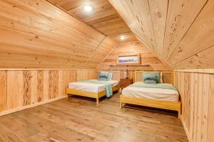 2 Betten in einem Zimmer mit Holzwänden und Holzböden in der Unterkunft Stunning Lake Granbury Retreat Gazebo and Fire Pit! in Granbury