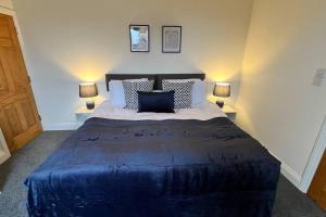a bedroom with a large blue bed with two lamps at Large apt, sleeps 4, in picturesque Wimborne town - The Westborough Nook in Wimborne Minster