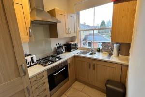 a kitchen with a stove and a sink and a window at Large apt, sleeps 4, in picturesque Wimborne town - The Westborough Nook in Wimborne Minster