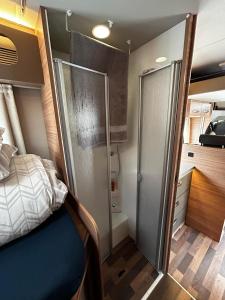 Schlafzimmer mit einem Bett und einer Glasschiebetür in der Unterkunft London Explorers' Pod, Vaaroom in Romford