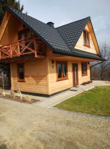 una gran casa de madera con techo negro en Chrząszczewo Widokowe Wzgórze 3 en Uherce Mineralne