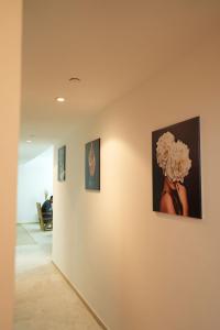 a hallway with three paintings on a wall at Curve Hostel JBR in Dubai