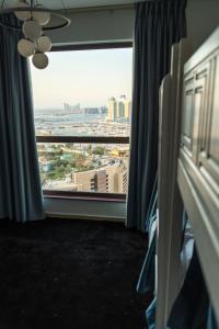 a room with a window with a view of a city at Curve Hostel JBR in Dubai