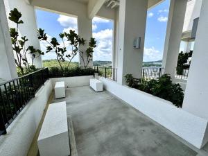 a balcony with two white benches and large windows at 2R2B GAIA RESIDENCE Gamuda Garden Rawang SkylineLuge in Rawang