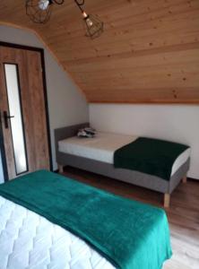 1 dormitorio con 2 camas y techo de madera en Chrząszczewo Widokowe Wzgórze 3 en Uherce Mineralne