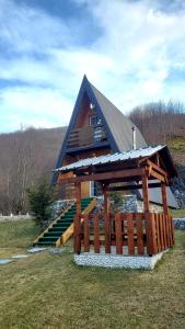 a house with a roof with a staircase in a field at Vilat Pllumaj in Gropat e Selcës