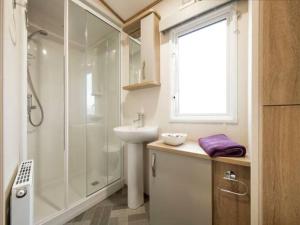 bagno bianco con doccia e lavandino di Pass the Keys Beautiful Cosy Holiday Home in Gorgeous Location a Beattock