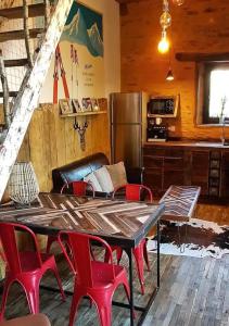a living room with a table and red chairs at La Grange in Sarlande