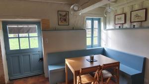 a dining room with a table and chairs and a door at Magnifique ferme landaise 12 couchages in Allons